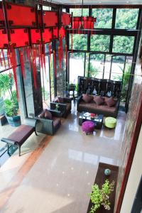 a living room with couches and tables and windows at Bonito Chinos Hotel in Nakhon Sawan