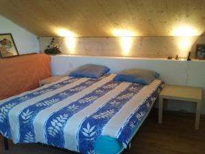 - une chambre dotée d'un lit bleu et blanc avec deux oreillers dans l'établissement Chambre Chaleureuse chez l'habitant, à Bourg-en-Bresse