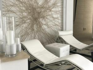 two white chairs in a room with a wall at Hotel Terme Marine Leopoldo II TERME & SPA in Marina di Grosseto