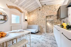 フィレンツェにあるGiglio Oroの石壁のリビングルームとキッチンが備わります。