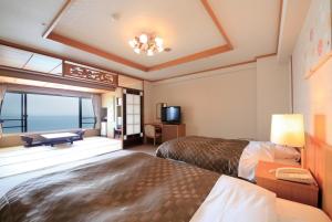 a hotel room with two beds and a balcony at Heiseikan Shiosaitei Hanatsuki in Hakodate