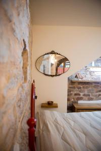 La Residenza Dei Cappuccini في سبيلّو: غرفة نوم مع سرير ومرآة على الحائط