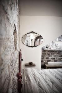 La Residenza Dei Cappuccini في سبيلّو: غرفة نوم مع سرير ومرآة على الحائط