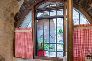 a window in a stone building with red curtains at La Residenza Dei Cappuccini in Spello
