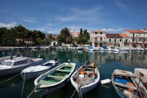 three boats are docked in a harbor with buildings at Apartments Toplak in Sućuraj