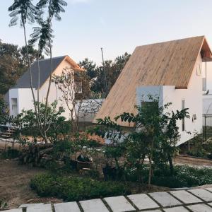 a white house with a wooden roof at Farm'ily in Da Lat