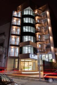 a tall apartment building with a car parked in front of it at Christina Hotel in Bucharest