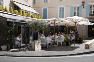 a group of people sitting at tables under umbrellas at Vieille Ville 2 - La Petite Maison à Safranier, 2 bedrooms, max 4 adults and 2 kids in Antibes
