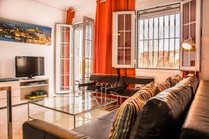 a living room with a couch and a tv at AlohaMundi Castilla I in Seville