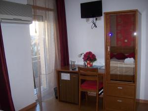 a room with a desk and a bedroom with a bed at Hotel Santa Apolonia in Bragança