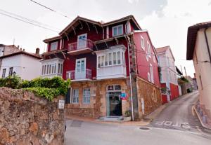 um edifício vermelho no lado de uma rua em Marina de Campios em Comillas