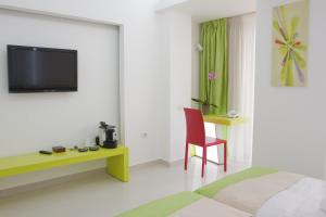 ein Schlafzimmer mit Fernseher, Tisch und Stuhl in der Unterkunft Christina Hotel in Bukarest