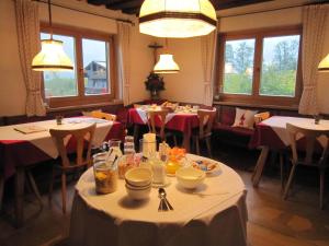 una sala da pranzo con tavoli, sedie e finestre di Pension Feiersinger a Kitzbühel