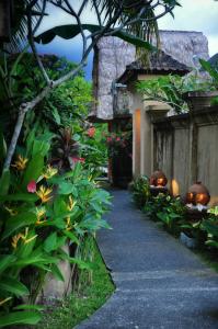 un passaggio pedonale in un giardino fiorito e un edificio di Sri Aksata Ubud Resort by Adyatma Hospitality ad Ubud