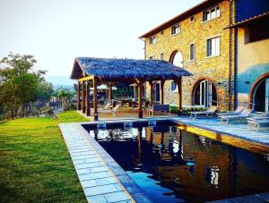a patio area with a pool and a building at Il Contado Country House & Spa in Poppi