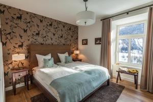 Un dormitorio con una cama y una pared con murciélagos. en Boutique-Hotel Garni Bellevue Davos Wiesen en Wiesen