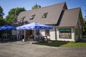 ein Geschäft mit blauen Sonnenschirmen vor einem Gebäude in der Unterkunft Kuremäe Hostel in Kuremäe