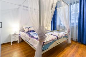 a bed with a canopy in a room with a window at Bucharest Pedestrian Old Town 3 Bedrooms by Orchid Garden in Bucharest