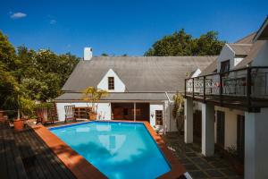 a swimming pool in front of a house at Cypress Cottage Guest House in Swellendam
