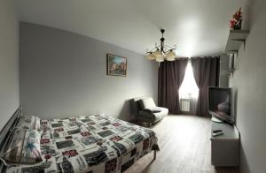 1 dormitorio con 1 cama, 1 silla y TV en Apartment Obolon metro station, en Kiev