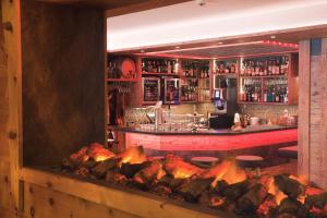 a bar with a fire grill in front of it at Hotel Hemizeus & Iremia Spa in Zermatt