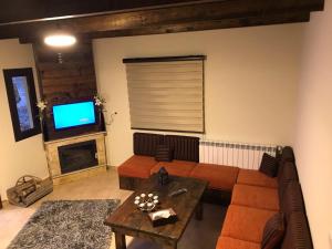 ein Wohnzimmer mit Sofa, Tisch und Fernseher in der Unterkunft Villars Lebanon in Mayrūbā