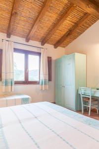 a bedroom with a large bed and a table at Hotel Sa Tanca E Bore in Siniscola