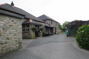 a stone building with a walkway between two buildings at Tricky's Hotel in Redruth