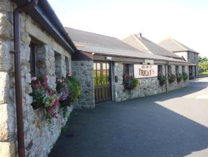 a stone building with flowers on the side of it at Tricky's Hotel in Redruth