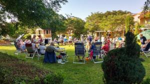 un grupo de personas sentadas en sillas de jardín en un patio en Zora Camping - Bungalows, en Obzor