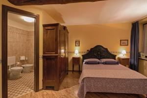 クーネオにあるB&B Contrada dei Giardiniのベッドルーム1室(ベッド1台付)、バスルーム(トイレ付)