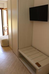 蘭佩杜薩的住宿－Casette D'amore，一间设有长凳的墙上电视的房间