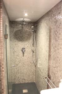 baño con ducha y puerta de cristal en Barcelona Beach Apartments, en Barcelona