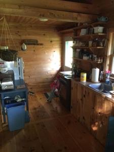 a kitchen with a stove and a sink in a cabin at Camp Mitigwa Rental in Rangeley
