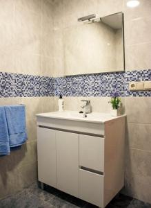 een badkamer met een witte wastafel en een spiegel bij Apartamento Palacio Antigua Audiencia in Ciudad-Rodrigo