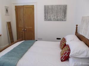 a bedroom with a bed with two pillows on it at The Beatnik, Victorian townhouse apartment with parking in Plymouth