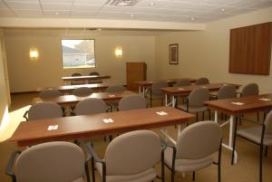 una sala de conferencias con mesas y sillas. en Super 8 by Wyndham Campbellton NB, en Campbellton