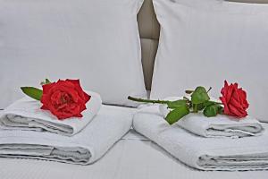 two roses are sitting on towels on a bed at Element Hotel in Elafonisos