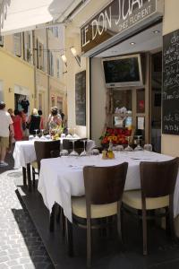 Vieille Ville 2 - La Petite Maison à Safranier, 2 bedrooms, max 4 adults and 2 kids في أنتيب: مطعم بطاولات بيضاء وكراسي في شارع