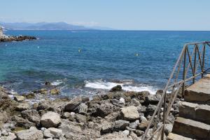 a staircase leading to the ocean with rocks and water at Vieille Ville 2 - La Petite Maison à Safranier, 2 bedrooms, max 4 adults and 2 kids in Antibes