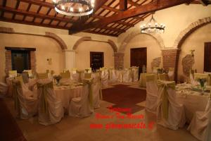 a large room with tables with white table cloths and chairs at Hotel Residence La Fortezza in San Lucido