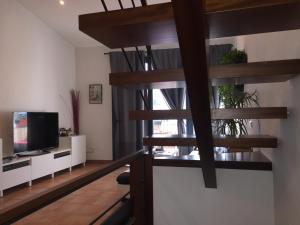 カダケスにあるCal Montaner Casa 3 habitaciones 3 baños y Garajeのリビングルーム(らせん階段、テレビ付)