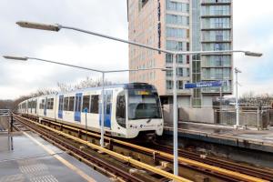 a white and blue train is on the tracks at ART Hotel Rotterdam-Fully Renovated in Rotterdam