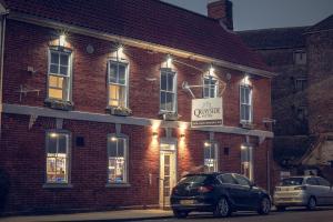 two cars parked in front of a brick building at Quayside Hotel & Bar in Boston