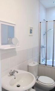 a white bathroom with a toilet and a sink at The Beatnik, Victorian townhouse apartment with parking in Plymouth