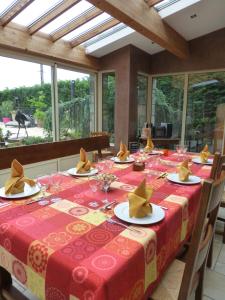 uma mesa de jantar com uma toalha de mesa vermelha e amarela em Carpe Diem em Soucieu-en-Jarrest