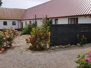 a fence in front of a house with flowers at Peterslund in Östra Tommarp
