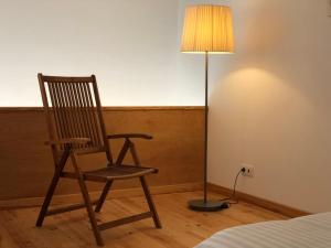 a rocking chair next to a lamp in a bedroom at Casa d'Avó Francisco in Madalena