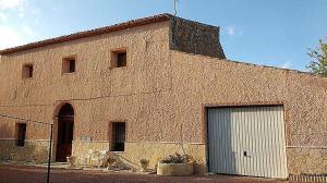 un gran edificio de ladrillo con un gran garaje en The Pink House, en El Pinós (Pinoso)
