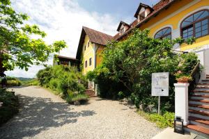 una casa amarilla con un cartel delante en Sattlerhof Genießerhotel & Weingut en Gamlitz